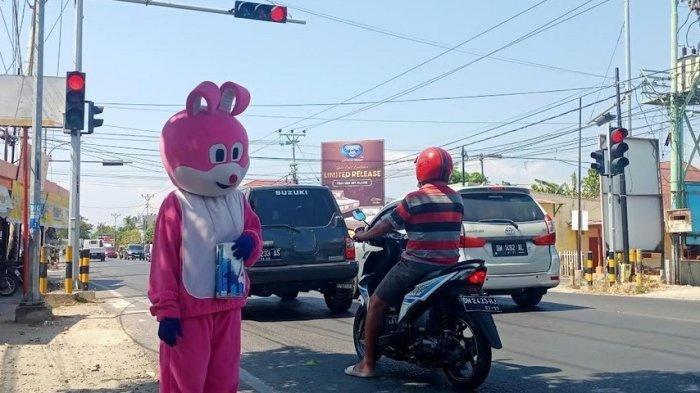 ARSIP FOTO -- Seorang badut berdiri di bibir jalan, mengiba diri ke para pengendara, kadang bertingkah kocak untuk dapat perhatian. Namun, badut-badut ini akan ditertibkan di Kota Gorontalo. Mereka dilarang beroperasi di lampu merah. FOTO: Herjianto, TribunGorontalo.com