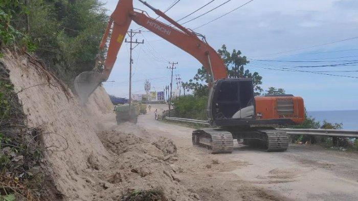 Alat berat tengah mengeruh tanah untuk memperlebar jalan