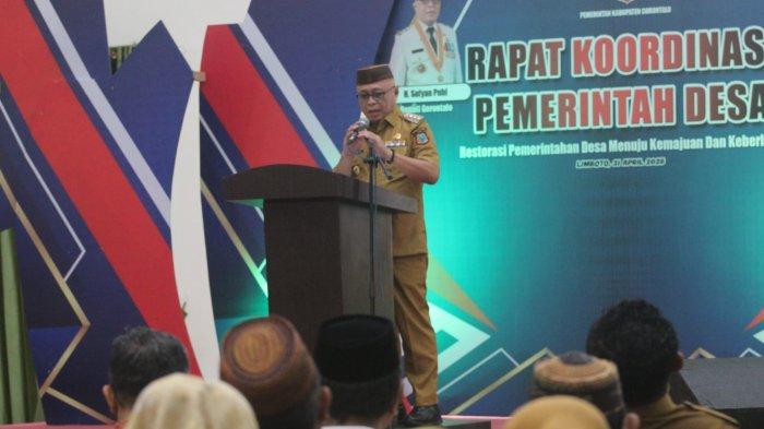 RAPAT KOORDINASI - Bupati Gorontalo Sofyan Puhi saat memberikan sambutan di depan Pemdes dan OPD Kabupaten Gorontalo. Bupat Sofyan membuka rapat koordinasi (rakor) tentang penyampaian pokok-pokok kebijakan restorasi tata kelola pemerintahan Kabupaten Gorontalo, Senin (21/4/2025). (Sumber Foto: Humas Pemkab Gorontalo)
