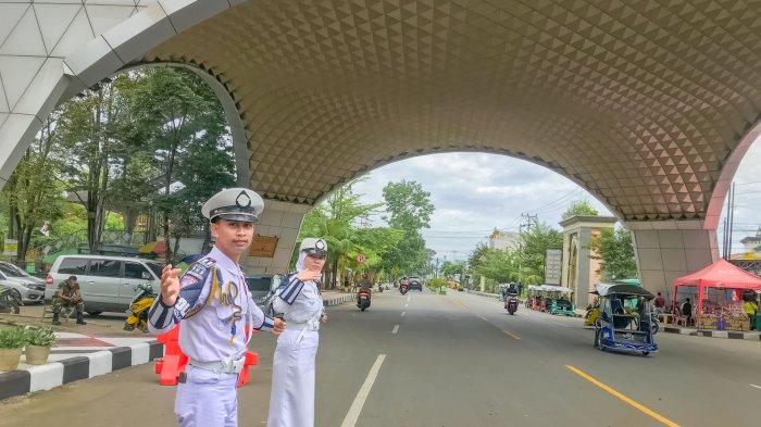 Vanda Praningsih Diu dan Melki K. Bempa, siswa berasal dari SMAN 2 Limboto saat mengurai kemacetan di Menara Limboto, Kabupaten Gorontalo, Sabtu (28/12/2024).