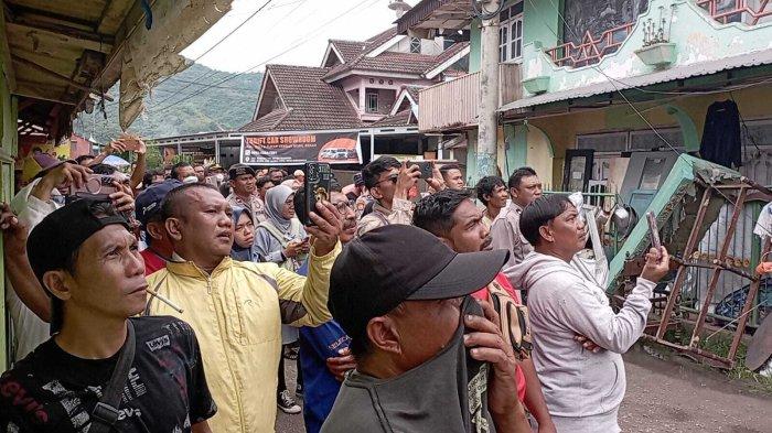 EKSEKUSI RUMAH - Potret sejumlah warga menyaksikan proses eksekusi rumah di Kelurahan Bugis, Kecamatan Kota Barat, Kota Gorontalo, Selasa (23/4/2025). Rumah di atas lahan sengketa ini diawasi ketat oleh 100 personel TNI-Polri.