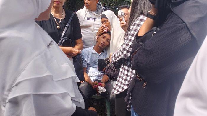 Fandy Ahmad, suami Sri Meyke Male hanya bisa duduk lesu menyaksikan prosesi pemakaman mendiang istrinya.