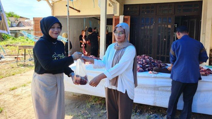 GRANDQ BERBAGI KURBAN -- Direktur Operasional Grand Q Hotel Gorontalo, Rima Fazriah Usman saat membagikan secara simbolis daging kurban kepada warga.