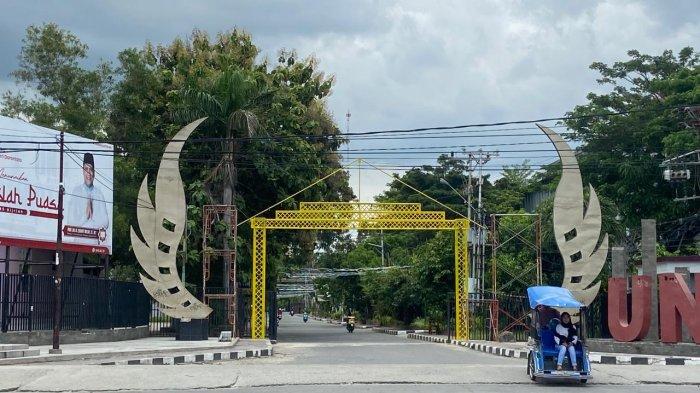 Gerbang Universitas Negeri Gorontalo (UNG). Tampak sebuah alikusu atau menara lampu berwarna kuning menyambut para penikmat Tumbilotohe Gorontalo.