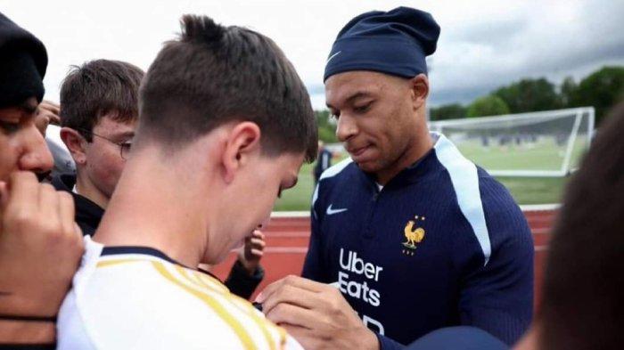 Kylian Mbappe menandatangani jersi fans Real Madrid