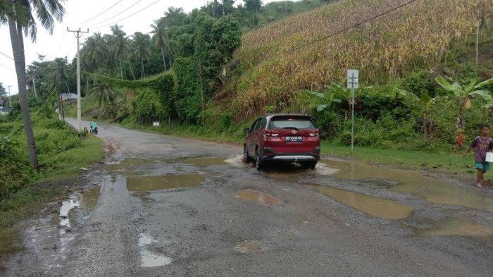 JALAN RUSAK - Mobil saat melewati Jalan Trans Sulawesi yang berada di Desa Bulango Raya, Kecamatan Tomilito, Kabupaten Gorontalo Utara, Provinsi Gorontalo yang rusak parah pada Sabtu (01/02/2025). Warga berharap jalan tersebut segera diperbaiki