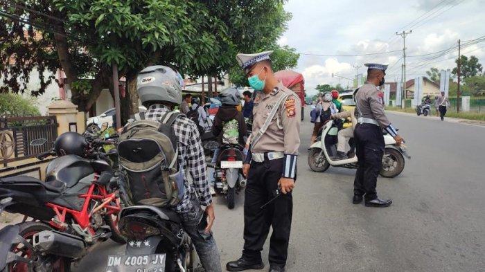 OPERASI PATUH LALU LINTAS - Seorang warga diberhentikan polisi dalam operasi patuh Otanaha 2025, Senin (17/2/2025). Polisi memberikan helm kepada pengendara yang taat aturan. FOTO: Moh Zulpama Hulopi