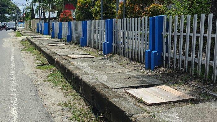POTRET DRAINASE - Potret Drainase di Kawasan Kota Tua Kota Gorontalo tampak ditutupi dengan papan seadanya. Tepat di jalan MT Haryono trotoar rusak diisi oleh para pedagang yang berjualan di pasar senggol. Foto (TribunGorontalo.com/Arianto Panambang).