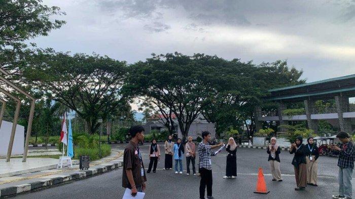 PENTAS JALANAN - Potret mahasiswa HMJ Bastrasia Universitas Negeri Gorontalo (UNG) membaca puisi di depan gerbang kampuns, Selasa (22/4/2025) sore. Pentas jalanan ini disaksikan oleh mahasiswa dan menjadi pusat perhatian pengguna jalan.