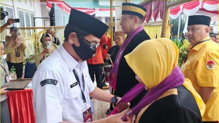 Plt KPU Provinsi Gorontalo Risan Pakaya mengalungkan salendang ke Idah Syahidah dan Gusnar Ismail saat tiba di Kantor KPU Provinsi Gorontalo pada Kamis (29/8/2024). (Foto: TribunGorontalo.com/Arianto)