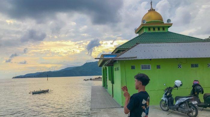 PEMANDANGAN INDAH -- Potret warga memancing di belakang Masjid At-Thoha, Minggu (29/6/2025). Masjid At-Thoha menyajikan panorama indah sunset.