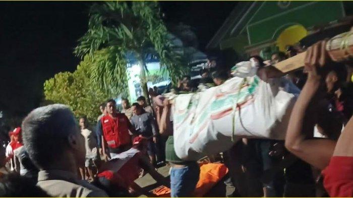 Salah satu korban tambang longsor dievakuasi, dipopang kayu dan dibungkus dengan karung, Minggu (7/7/2024) malam.
