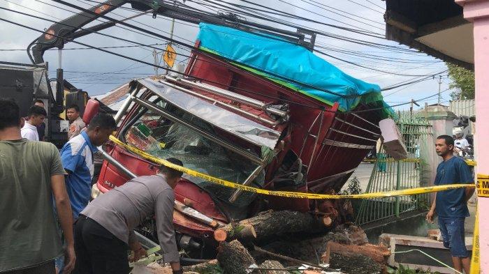 KECELAKAAN TRUK: Sebuah truk menabrak pagar rumah di Kelurahan Hunggaluwa, Limboto, Kabupaten Gorontalo, pada Jumat (14/2025). Sejumlah warga hingga kepolisian berusaha mengevakuasi truk.