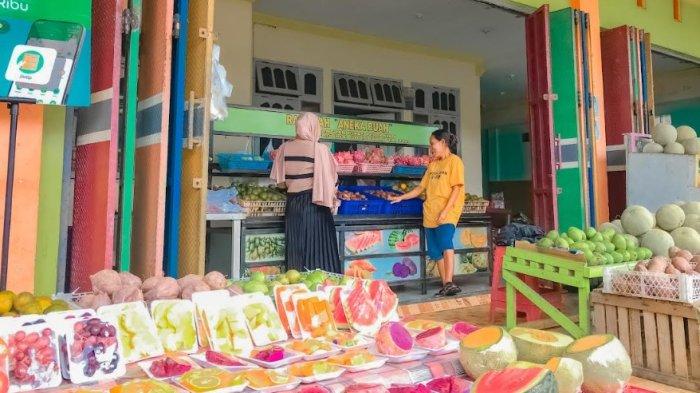 UMKM BUAH--Apriyanti molose (28) dan Nindi Molose (23) merupakan kakak beradik yang menjalankan usaha buah di Jalan Kalimantan, Kota Tengah, Kota Gorontalo, Provinsi Gorontalo, Sabtu (26/4/2025), Foto: TribunGorontalo.com/Jefri Potabuga.