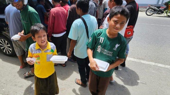 PEGADAIAN - Pegadaian Area Gorontalo bagi makanan kepada masyarakat sekitar melalui program 'Mengetuk Pintu Langit'.
