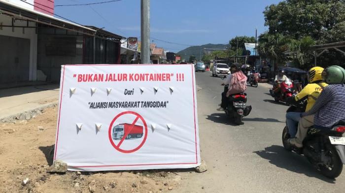 KERUSAKAN JALAN -- Bentuk protes soal kenderaan kontainer, warga buat spanduk, Senin (28/7/2025). Spanduk bertuliskan 'Bukan Jalur Kontainer' merupakan bentuk protes warga