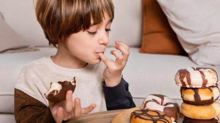 Ilustrasi anak mengonsumsi makanan manis, berikut ini dampak mengonsumsi makanan manis terlalu banyak
