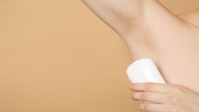Ilustrasi seseorang yang menggunakan deodorant untuk mengurangi bau badan