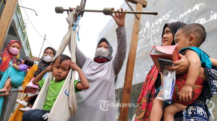 ILUSTRASI Penimbangan Bulanan Anak Nasional --- FOTO: Warga memeriksakan kesehatan balitanya di Pos Pelayanan Terpadu (Posyandu) Teratai 6A, RW 06, Desa Cangkuang Kulon, Kecamatan Dayeukolot, Kabupaten Bandung, Jawa Barat, Jumat (12/11/2021). Kementerian Kesehatan akan menggerakkan kader Posyandu yang diformalkan agar layanan Posyandu bisa melayani warga hingga level desa.
