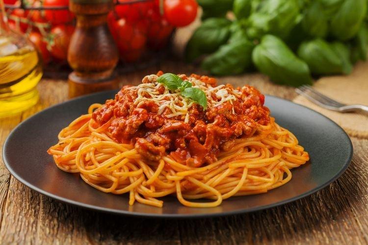 ilustrasi pasta dengan taburan keju dan tomat
