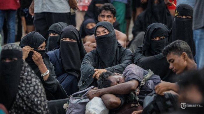 Pengungsi Rohingya yang baru tiba beristirahat di pantai setelah masyarakat setempat memutuskan untuk mengizinkan mereka sementara mendarat untuk mendapatkan air dan makanan di Ulee Madon, provinsi Aceh, Indonesia, pada 16 November 2023. (Photo by amanda jufrian / AFP) | Menko Polhukam Mahfud MD menyebut para pengungsi Rohingya yang ada di Aceh, Sumatera Utara, dan Riau tidak ingin keluar dari Indonesia.