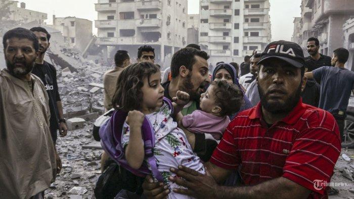 Orang-orang membawa anak-anak saat mereka melarikan diri, menyusul serangan Israel di Rafah di Jalur Gaza selatan pada 15 Oktober 2023. Israel memulai kampanye udara melawan militan Hamas di Gaza setelah mereka melakukan serangan brutal terhadap Israel pada 7 Oktober yang meninggalkan lebih dari 1.400 orang terbunuh di Israel.