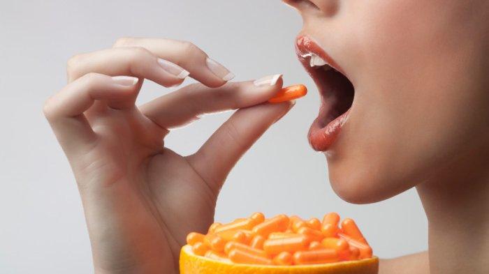 ilustrasi seseorang mengonsumsi vitamin C