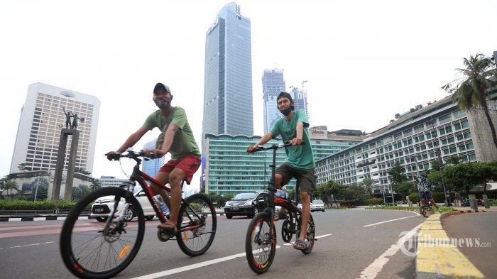 Warga menikmati suasana pagi akhir pekan dengan bersepeda di kawasan Bundaran HI, Jakarta Pusat, Minggu (11/10/2020).