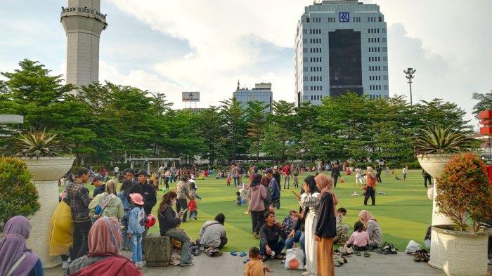 Warga mengisi waktu berbuka puasa di lapangan rumput sintetis Taman Alun-Alun Kota Bandung, Jawa Barat, Sabtu (8/4/2023).