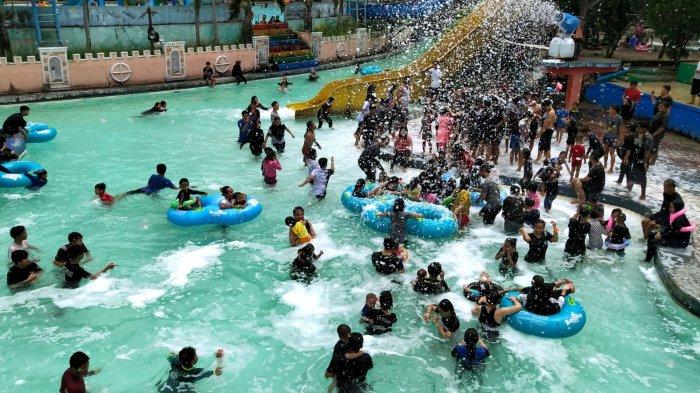 Pengunjung yang sedang berenang menyempatkan bermandi busa saat berwisata di Karang Setra Waterland, Kota Bandung, Jawa Barat, Kamis (18/5/2023).