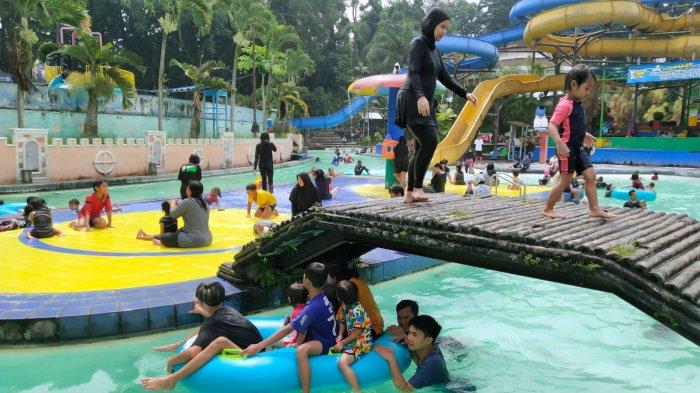 Pengunjung bermain di salah satu kolam renang saat berwisata di Karang Setra Waterland, Kota Bandung, Jawa Barat, Kamis (18/5/2023).