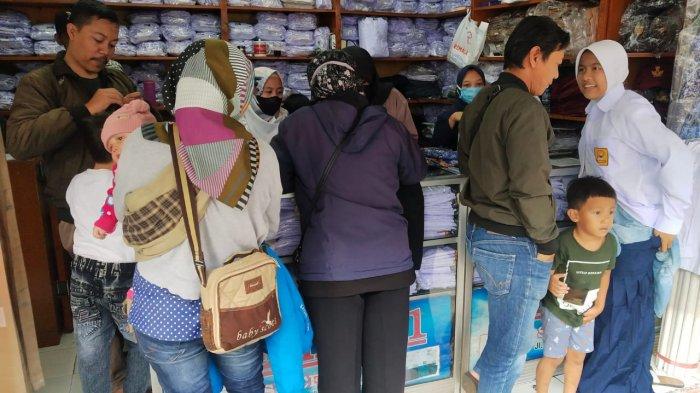 Orang tua membelikan seragam sekolah untuk anaknya di salah satu toko perlengkapan seragam sekolah, di Jalan Cipaera, Kosambi, Kota Bandung, Jawa Barat, Senin (10/7/2023).