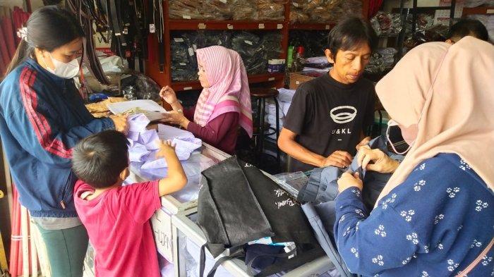 Orang tua membelikan seragam sekolah untuk anaknya di salah satu toko perlengkapan seragam sekolah, di Jalan Cipaera, Kosambi, Kota Bandung, Jawa Barat, Senin (10/7/2023).