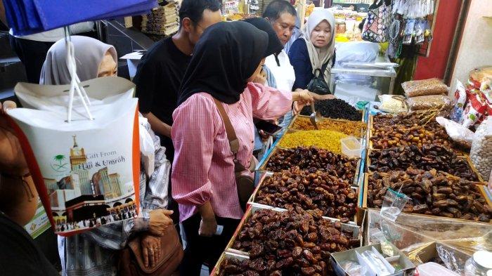 Pengunjung berbelanja oleh-oleh haji di salah satu toko oleh-oleh haji dan umroh di Pasar Baru Trade Center, Jalan Otto Iskandar Dinata, Kota Bandung, Jawa Barat, Selasa (11/7/2023).