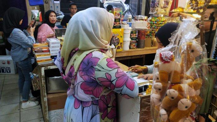 Pengunjung berbelanja oleh-oleh haji di salah satu toko oleh-oleh haji dan umroh di Pasar Baru Trade Center, Jalan Otto Iskandar Dinata, Kota Bandung, Jawa Barat, Selasa (11/7/2023).