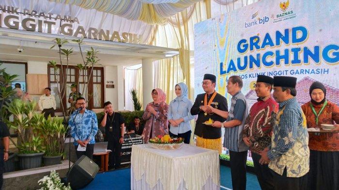Gubernur Jawa Barat Ridwan Kamil bersama istri Atalia Praratya, didamping Wakil Ketua Badan Amil Zakat Nasional Republik Indonesia (Baznas RI) Mokhamad Mahdum dan sejumlah pejabat terkait lainnya memberikan potongan tumpeng kepada perwakilan dari keluarga Inggit Garnasih pada peresmian Klinik Pratama Inggit Garnasih di Jalan Flores, Kota Bandung, Jawa Barat, Kamis (20/7/2023).