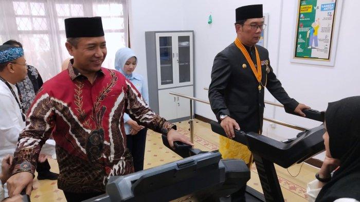 Gubernur Jawa Barat, Ridwan Kamil bersama Wakil Ketua Badan Amil Zakat Nasional Republik Indonesia (Baznas RI), Mokhamad Mahdum mencoba alat cardio saat meninjau sejumlah fasilitas seusai meresmikan Klinik Pratama Inggit Garnasih di Jalan Flores, Kota Bandung, Jawa Barat, Kamis (20/7/2023).