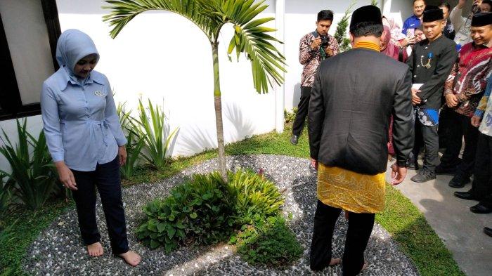Gubernur Jawa Barat, Ridwan Kamil bersama istri Atalia Praratya mencoba refleksi kaki, berjalan di atas batu tanpa alas kaki di area taman saat meninjau sejumlah fasilitas seusai 
meresmikan Klinik Pratama Inggit Garnasih di Jalan Flores, Kota Bandung, Jawa Barat, Kamis (20/7/2023).