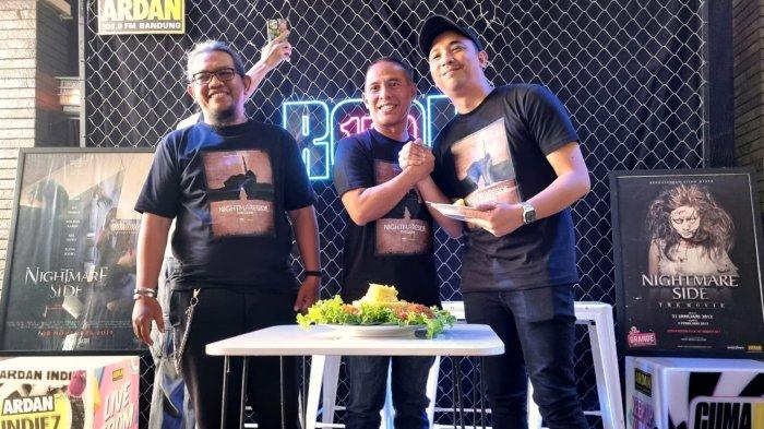 Direktur Ardan Mindworks Roni Patoroni (tengah) memberikan potongan nasi tumpeng kepada Program Manager Ardan Radio Dimas Tri Aditiyo (kanan) seusai konferensi pers Nightmare Side The Games, di Ardan Radio, Jalan Cipaganti, Kota Bandung, Jawa Barat, Kamis (10/8/2023).