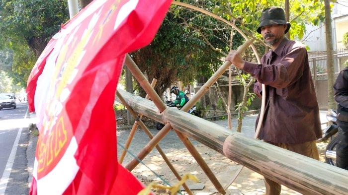 Alamsyah (56), memasang bilah bambu melingkar di ujung batang bambu tali/apus saat membuat bambu panjat pinang di Jalan Moch. Toha, Kota Bandung, Jawa Barat, Senin (14/8/2023).