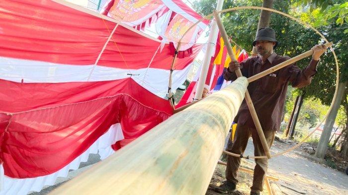 Alamsyah (56), memasang bilah bambu melingkar di ujung batang bambu tali/apus saat membuat bambu panjat pinang di Jalan Moch. Toha, Kota Bandung, Jawa Barat, Senin (14/8/2023).