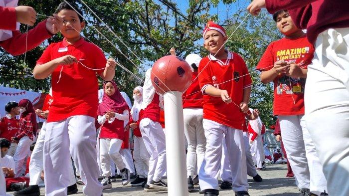 Para siswa mengikuti lomba memindahkan bola dengan paralon dalam rangka memperingati HUT ke-78 Kemerdekaan RI di halaman Darul Hikam Integrated School (DHIS) Primary, Jalan Brigjen Katamso, Kota Bandung, Jawa Barat, Rabu (16/8/2023).
