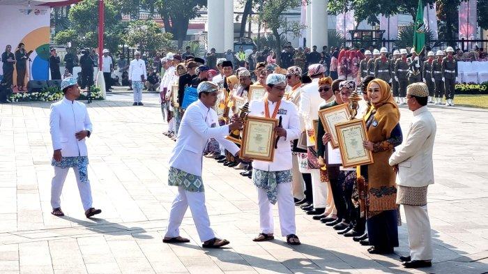 Gubernur Jawa Barat, Ridwan Kamil menyerahkan piagam penghargaan pada Upacara Peringatan Hari Jadi ke-78 Provinsi Jawa Barat, di Lapangan Gasibu, Jalan Diponegoro, Kota Bandung, Jawa Barat, Sabtu (19/8/2023).