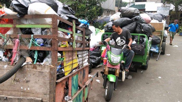 Petugas memarkirkan gerobak motor berisi tumpukan sampah berjejer dengan gerobak sampah lainnya yang juga berisi tumpukan sampah yang belum diturunkan di Tempat Pembuangan Sementara (TPS) Pasar Ancol, Jalan Pungkur, Kelurahan Ancol, Kecamatan Regol, Kota Bandung, Jawa Barat, Rabu (23/8/2023).