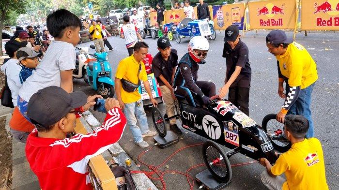 Panitia menimbang peserta bersama keretanya seusai masuk finish dalam Lomba Kereta Peti Sabun (LKPS) Kesepuluh 2023 Jalan Diponegoro, Kota Bandung, Jawa Barat, Sabtu (26/8/2023).