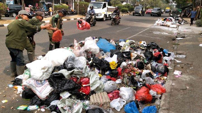 Petugas Gober merapikan tumpukan sampah agar tidak berserakan di pinggir Jalan Jamika, Kota Bandung, Jawa Barat, Senin (28/8/2023).