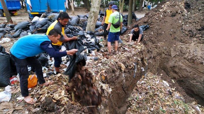 Petugas Ranger Dinas Perumahan dan Kawasan Permukiman (DPKP) Kota Bandung memasukan sampah organik jenis daun-daunan ke lubang yang baru selesai dibuat di area Taman Tegallega, Kota Bandung, Jawa Barat, Rabu (30/8/2023).