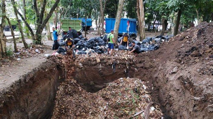 Petugas Ranger Dinas Perumahan dan Kawasan Permukiman (DPKP) Kota Bandung memasukan sampah organik jenis daun-daunan ke lubang yang baru selesai dibuat di area Taman Tegallega, Kota Bandung, Jawa Barat, Rabu (30/8/2023).