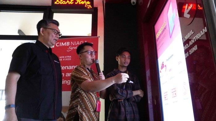 Chief of Audit Executive CIMB Niaga Antonius Gunadi (kiri) bersama mahasiswa yang juga nasabah (kanan) menyaksikan layanan TV Interaktif pada perayaan Hari Pelanggan Nasional (Harpelnas) 2023 bertema 