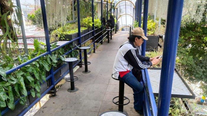 Warga duduk di kursi untuk beristirahat sejenak di jembatan penyeberangan orang (JPO) yang ditanami beragam tanaman hias, di Jalan Wastukencana, Kota Bandung, Jawa Barat, Senin (18/9/2023).